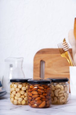 Ballı ve fındıklı cam kavanozlar. Mutfağın içinde badem, fındık ve fındık var..