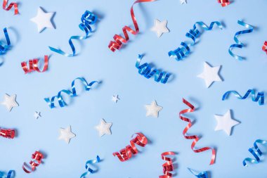 USA Independence day concept. Red and blue spirals and white stars elements of USA flag top view, flat lay on blue background. clipart