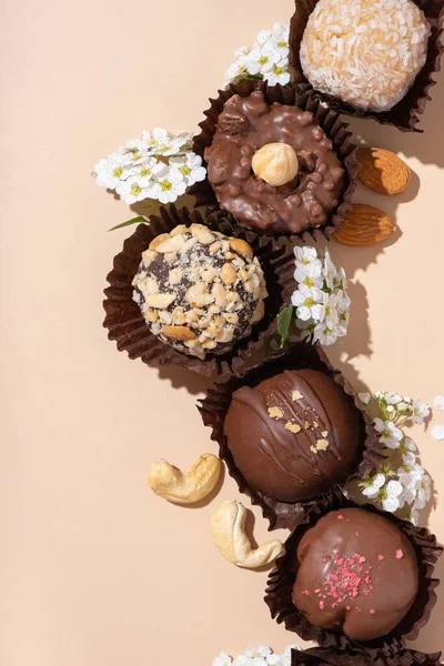 Chocolade Ambachtelijke Noten Snoepjes Witte Plaat Beige Achtergrond Platte Lay — Stockfoto