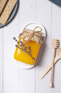 Ballı kavanoz ve lavanta çiçekli ahşap arka plan manzaralı, düz uzanmış.