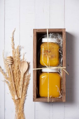 Ballı ve fındıklı kavanozlar ahşap kutunun üstünde, dümdüz yatıyordu..