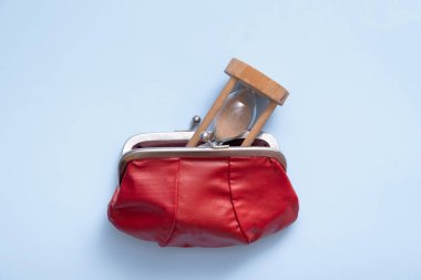 Cüzdanı kum saatli mavi arka planda düz, üst manzaralı. Yaratıcı minimalist kavram