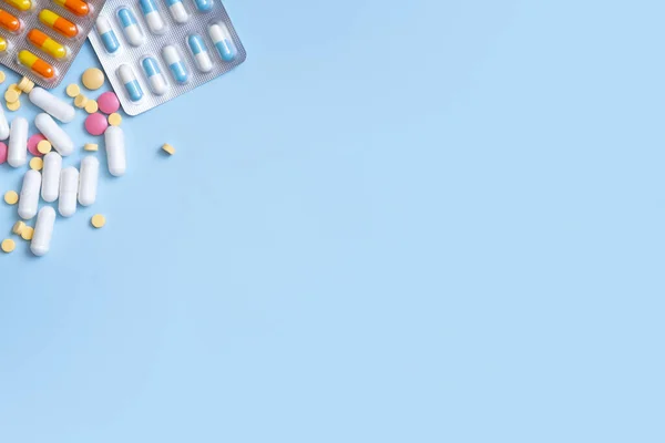 青の背景にカラフルな錠剤 ヘルスケアと医療の概念フラットレイアウト — ストック写真