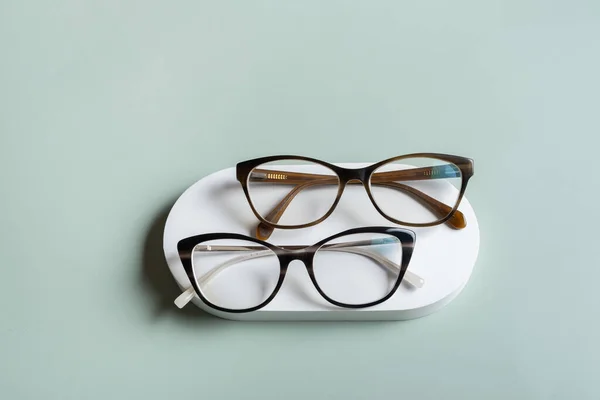 Podium Okularami Pastelowym Zielonym Tle Sklep Optyczny Test Wzroku Stylowa — Zdjęcie stockowe