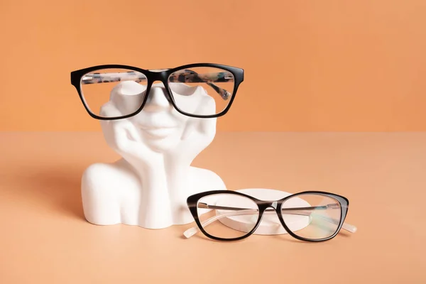 カラーバックグラスに眼鏡をかけた石膏の要素 光学店 ビジョンテスト スタイリッシュなメガネコンセプト — ストック写真