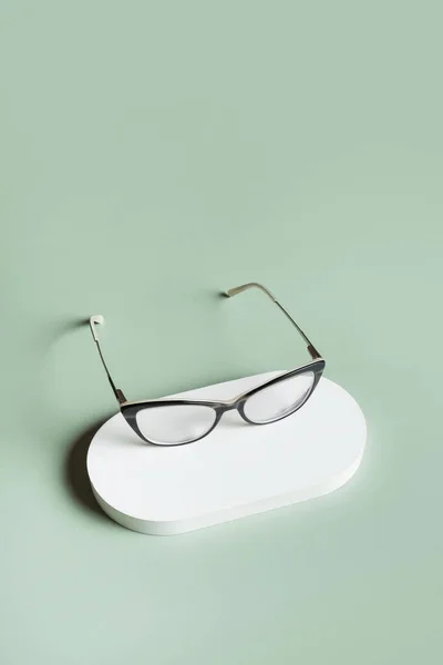 Podium Mit Brille Auf Pastellgrünem Hintergrund Optischer Laden Sehtest Stylisches — Stockfoto