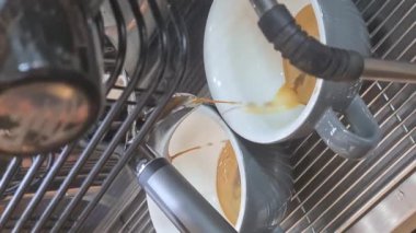 Kahve makinesi kafede iki fincanda espresso yapıyor. Dikey video. Yüksek kalite 4k görüntü
