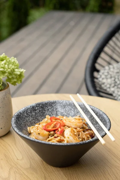 stock image Udon noodles with shrimp and stir-fried vegetables in a bowl on the terrace.