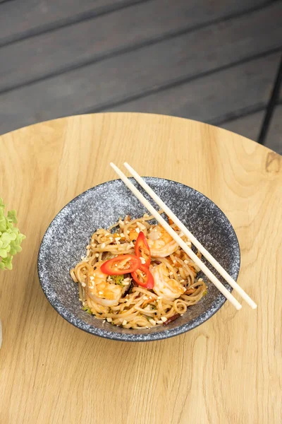 stock image Udon noodles with shrimp and fried vegetables in a bowl top view.