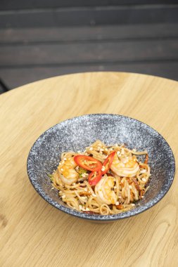 Tavan arasında karides ve kızarmış sebzeli Udon eriştesi.