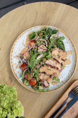 Sebzeli dana eti, sebzeli zeytin ve fındık soslu ahşap masa manzaralı bir tabak..