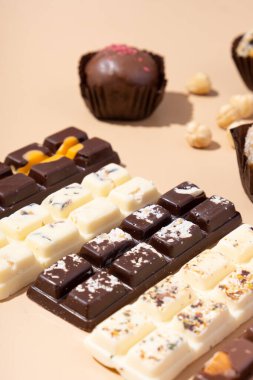 Bej arka planda beyaz, süt ve siyah çikolata şekerlemeleri..