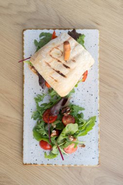 Tahta masa manzaralı et ve sebzeli hamburger..