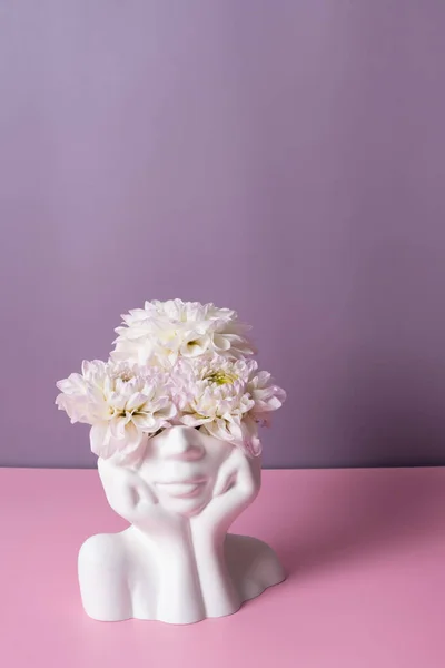Plaster head with flowers on a colored background. Mental health, mind care concept