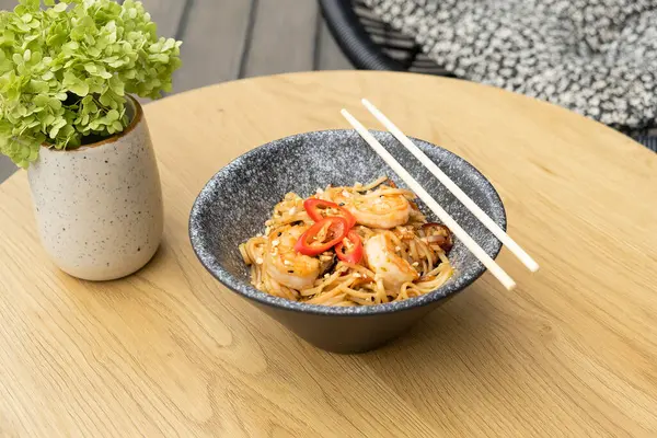 stock image Udon noodles with shrimp and fried vegetables in a bowl top view.