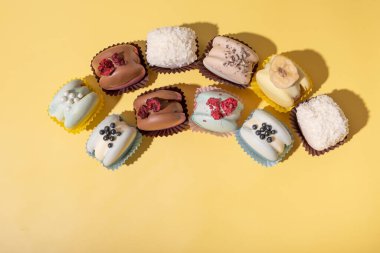 Sarı arka planda, düz bir zeminde farklı badem kurabiyeleri. Lezzetli lüks gıda estetiği