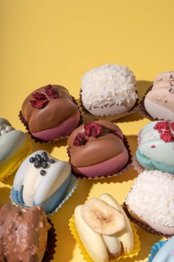 Sarı arka planda, düz bir zeminde farklı badem kurabiyeleri. Lezzetli yemek estetiği