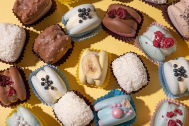 Farklı badem kurabiyeleri sarı arka planda düz bir zemine yakın dururlar. Lüks, lezzetli yemek estetiği.