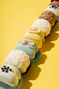 Sarı arka planda, düz bir zeminde farklı badem kurabiyeleri. Tatlı yemek konsepti