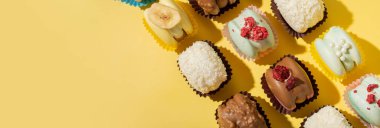 Sarı arka planda farklı badem kurabiyelerinin olduğu pankart düz yerde. Boşluğu kopyala