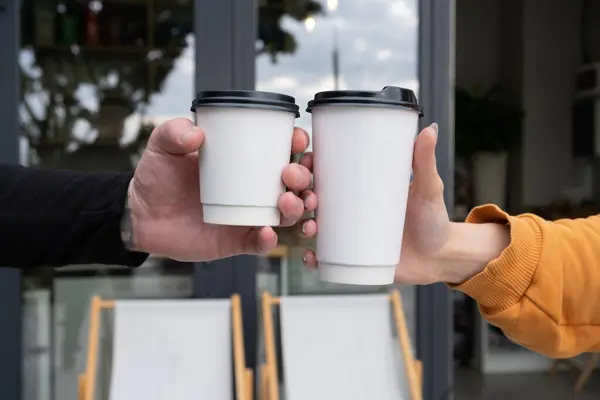 Two cardboard cups mock up in hands. Template for logo on drinks to go, takeaway.