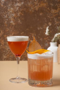 Bej kahverengi arka planda gözlüklü parlak alkollü kokteyller. Yakın plan.