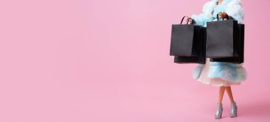 İndirimli, fotokopi alanı olan siyah cuma pankartı. Elinde siyah alışveriş torbaları olan bir bebek.