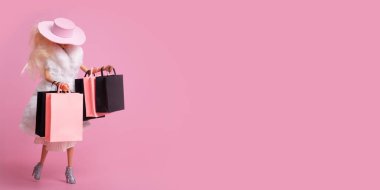 Elinde alışveriş torbaları olan oyuncak bebek. İndirim, Kara Cuma afişi. Alışveriş yapan kadın sembolü. Boşluğu kopyala