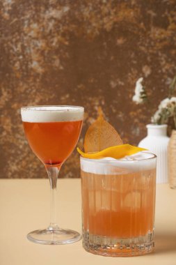 Bej kahverengi arka planda gözlüklü parlak alkollü kokteyller.