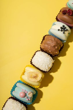 Sarı arkaplan görünümünde farklı badem kurabiyeleri, kopyalama alanı olan düz bir set..