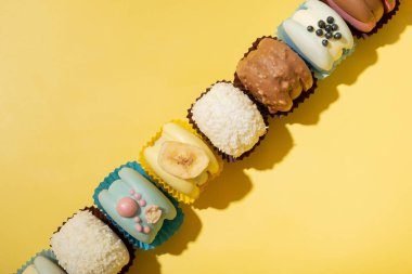 Sarı arka planda, düz bir zeminde farklı badem kurabiyeleri. Boşluğu kopyala