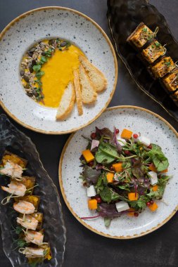 Kabak salatası ve çorba, karides ve terbiye edilmiş peynir kanepeleri. Arka planda, düz bir zemin üzerinde..