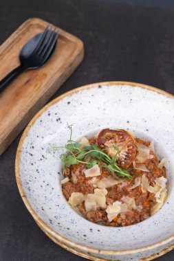 Koyu arkaplan manzaralı bir kasede bolonez, düz yatıyordu..