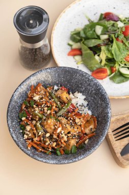 Lezzetli pirinç, et, sebze ve bej arka planda salata.