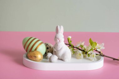 White rabbit, flowers and Easter eggs on a pink background and Easter eggs on a pink background.