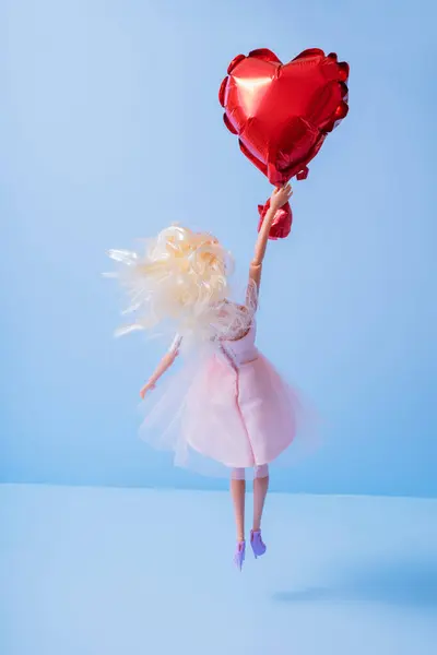 Valentines day love concept. Doll with flying with heart shaped balloon