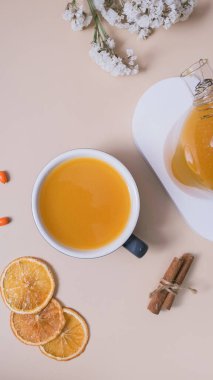 Bir bardak deniz dikenli çay ve badem kurabiyesi düzlüğü, üst manzara. Sıcak sonbahar kış zamanı.