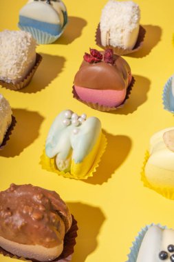 Sarı arka planda farklı badem kurabiyeleri. Lüks tatlı yiyecekler