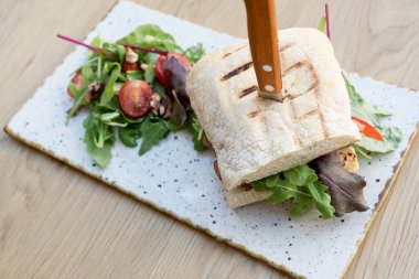 Tahta masa manzaralı et ve sebzeli hamburger..