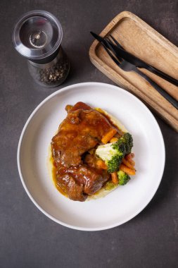 Barbekü soslu bir tabak sığır kaburgası. Sebze ve patates püresi..