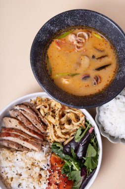 Pirinç, dana eti, sebze ve Tom tatlı patates çorbası manzaralı bir kase.