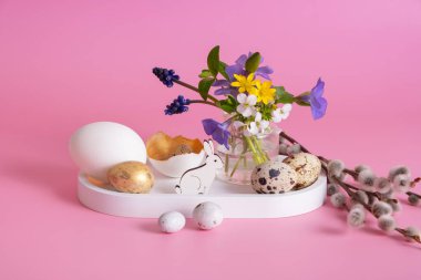 White rabbit, flowers and Easter eggs on a pink background and Easter eggs on a pink background.
