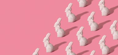 Paskalya için beyaz tavşan desenli afiş pembe arka planda izole edilmiş..