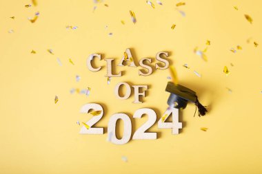 2024 sınıfı konsepti. 2024 numaralı mezuniyet şapkası sarı arka planda, süslemeli..