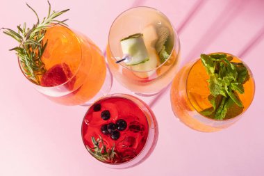 Renkli alkollü kokteylleri pembe arka plan manzaralı gözlüklerle kapat..