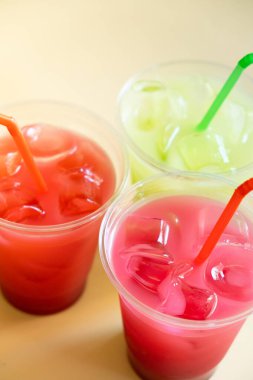 Bej arka planda buzlu üç renkli yaz içeceği..