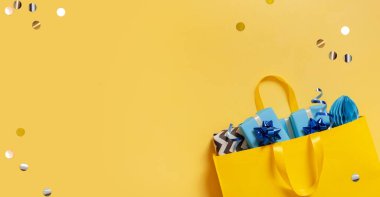 İçinde Noel hediyeleri olan sarı paket. Metin için yeri olan şenlikli düz konum