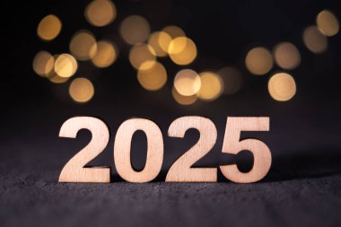 Yeni Yıl 2025 Bokeh ile ahşap numaralar halinde.