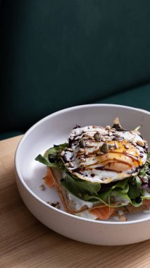 Kafe masasında yumurta ve tohumla bir kase waffle ve somon. Güzel yemek açısı manzarası.