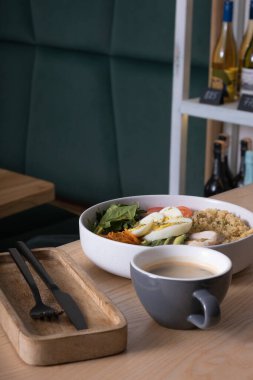 Et, yumurta, avokado, sebze ve kafe masasında bir fincan kahve..